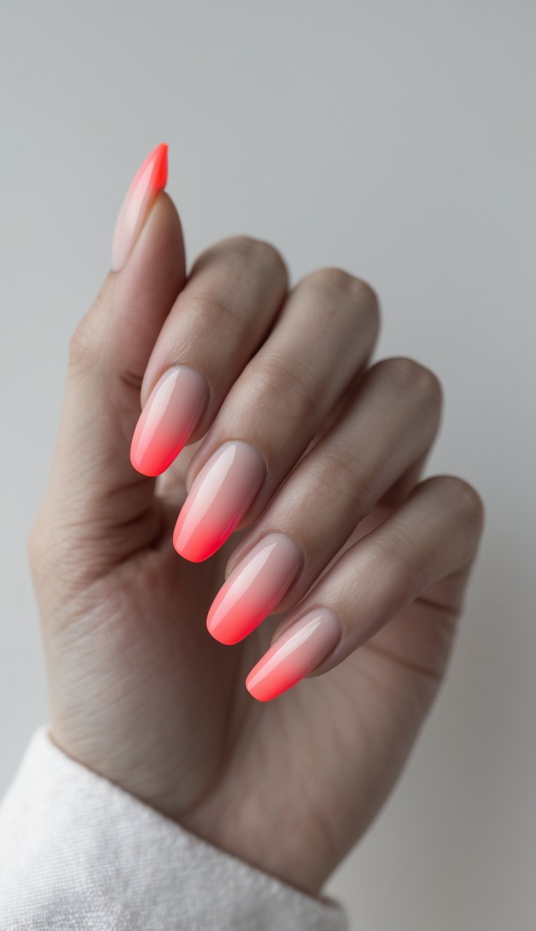 Close-up of one hand with nails painted in neon red fading from the tips against a white background.
