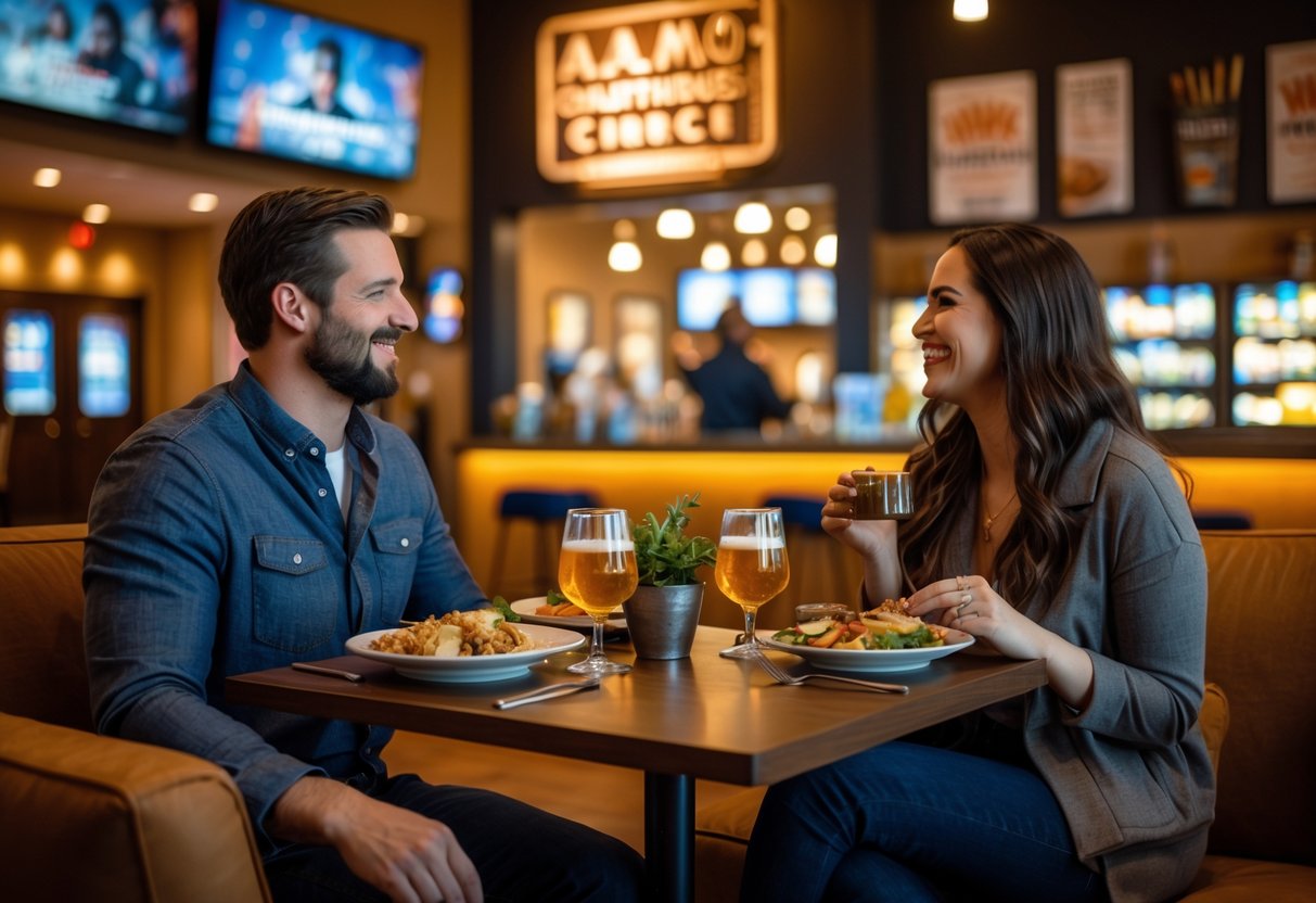A couple enjoying dinner and drinks together inside a cinema lobby with movie posters and snacks visible in the background.
