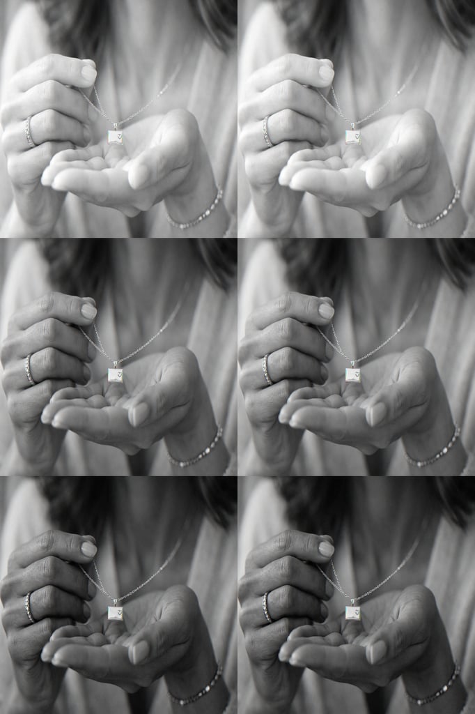 Close-up of a woman holding a delicate message card necklace in her hands.