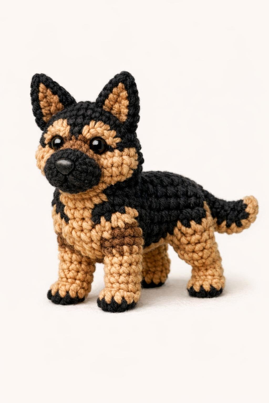 Close-up view of a crocheted German Shepherd dog standing, showing detailed yarn texture and black and tan markings.