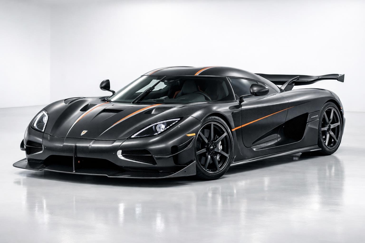 Foto mobil Koenigsegg Agera RS berwarna hitam dipajang di studio dengan pencahayaan terang, menampilkan desain aerodinamis dan detail mobil.