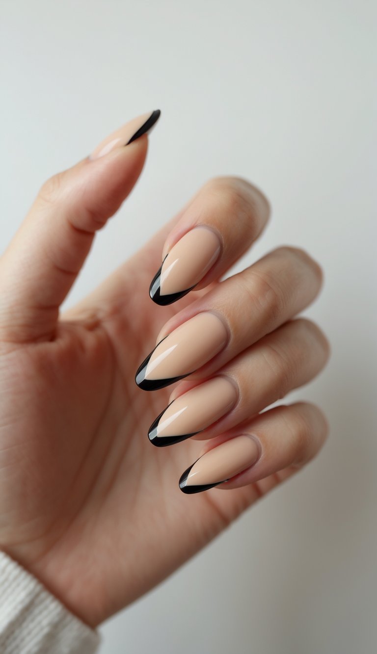 Close-up of one hand showing beige nails with black French tips against a white background.