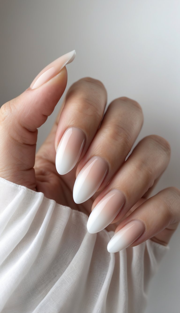 Close-up of one hand with French fade nails on a white background.