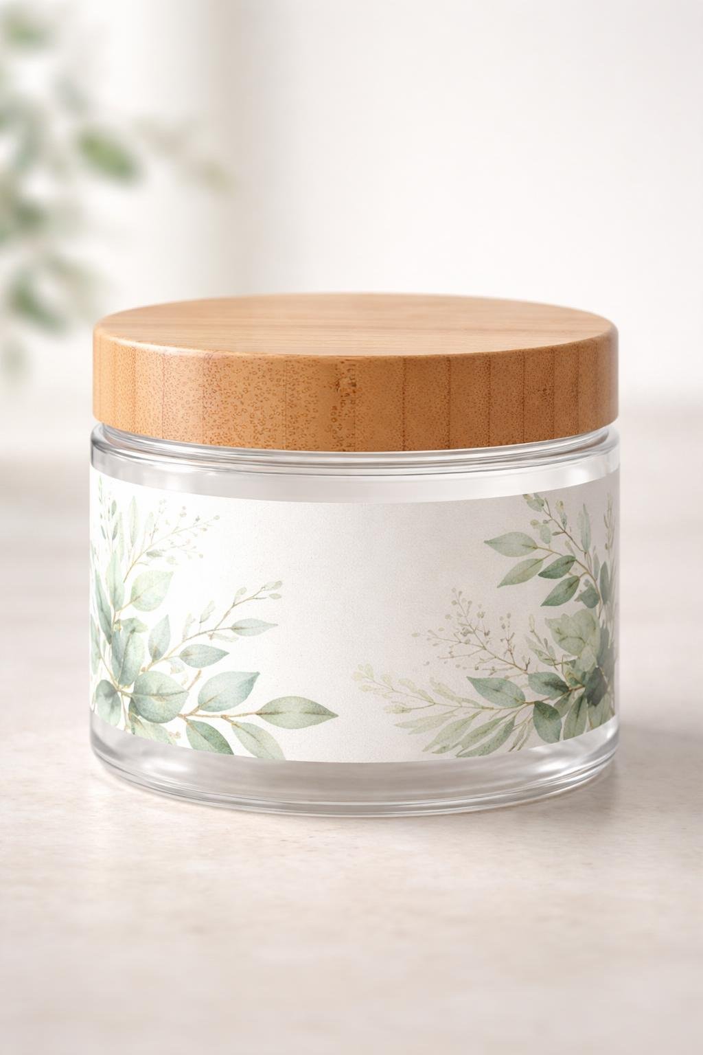 A clear jar with a bamboo lid and a botanical label sitting on a neutral surface.