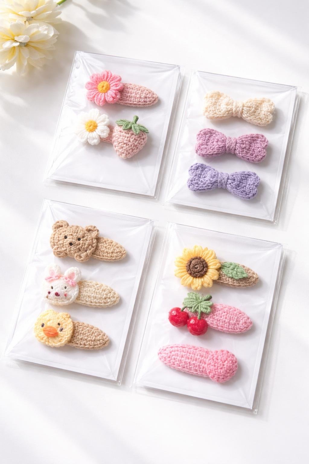 A set of colorful crochet snap hair clips neatly placed inside clear protective sleeves on a white surface.