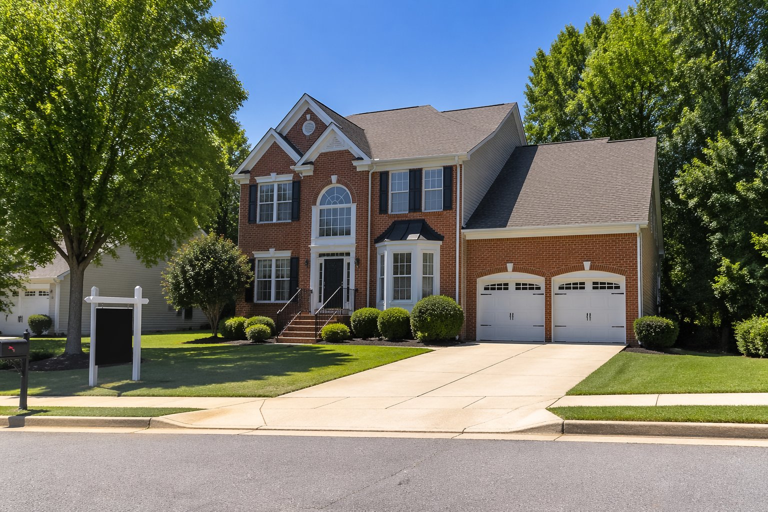 A two-story brick house with a manicured lawn and trees in a quiet suburban neighborhood on a sunny day.