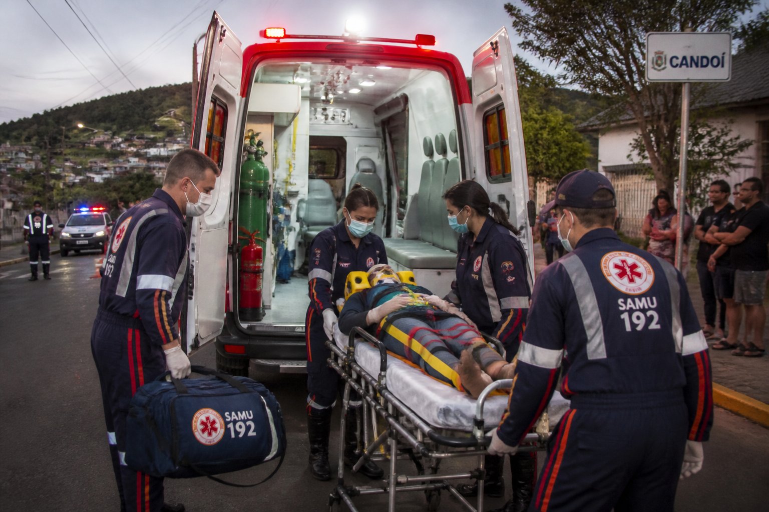 Equipe de resgate e atendimento pré-hospitalar atendendo paciente próximo a uma ambulância em Candói.