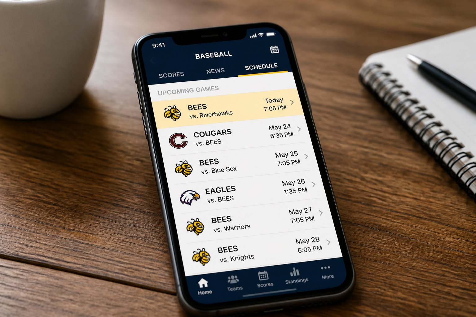 A smartphone on a wooden table displaying a baseball game schedule with the Bees team listed.