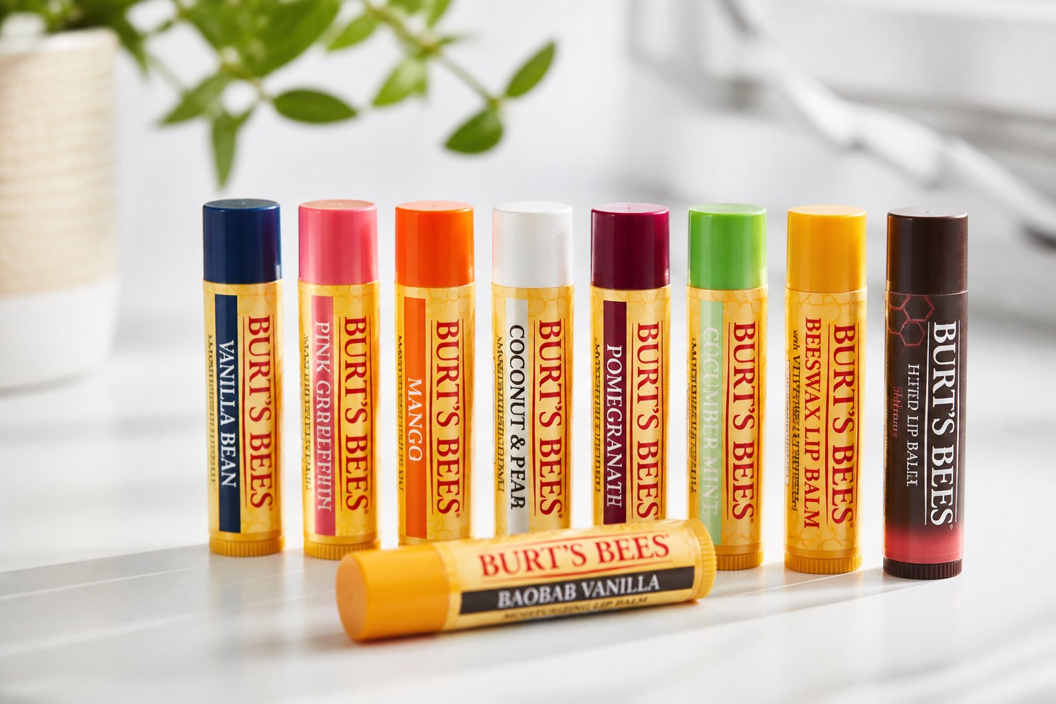 Several Burt's Bees lip balm tubes arranged neatly on a white surface with soft lighting.
