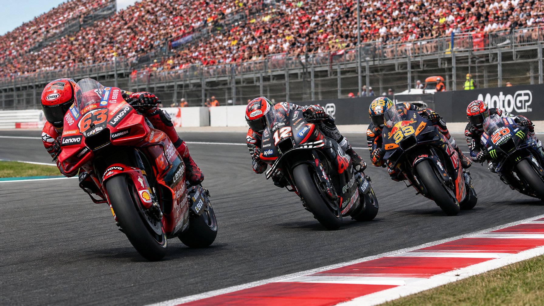Beberapa pembalap MotoGP dari Ducati, Aprilia, KTM, dan Yamaha sedang berlomba ketat di tikungan sirkuit dengan penonton di latar belakang.