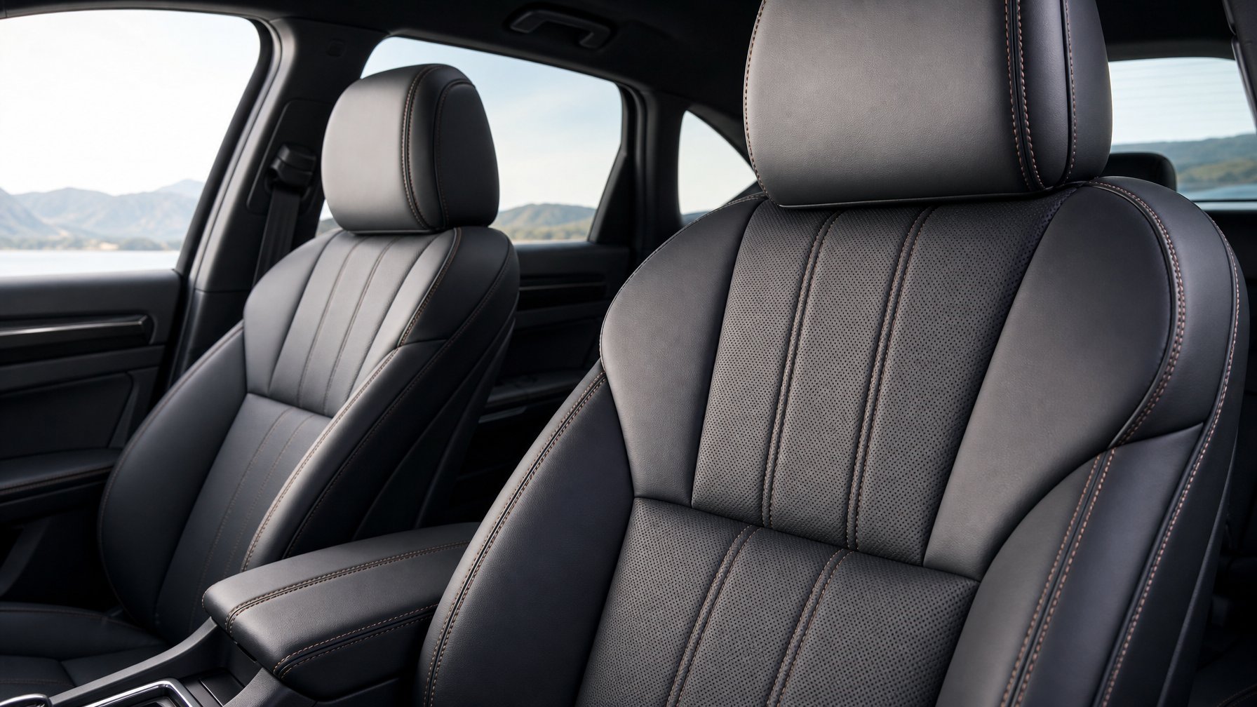 Interior mobil dengan jok kulit sintetis modern berwarna gelap yang terlihat elegan dan tahan lama.