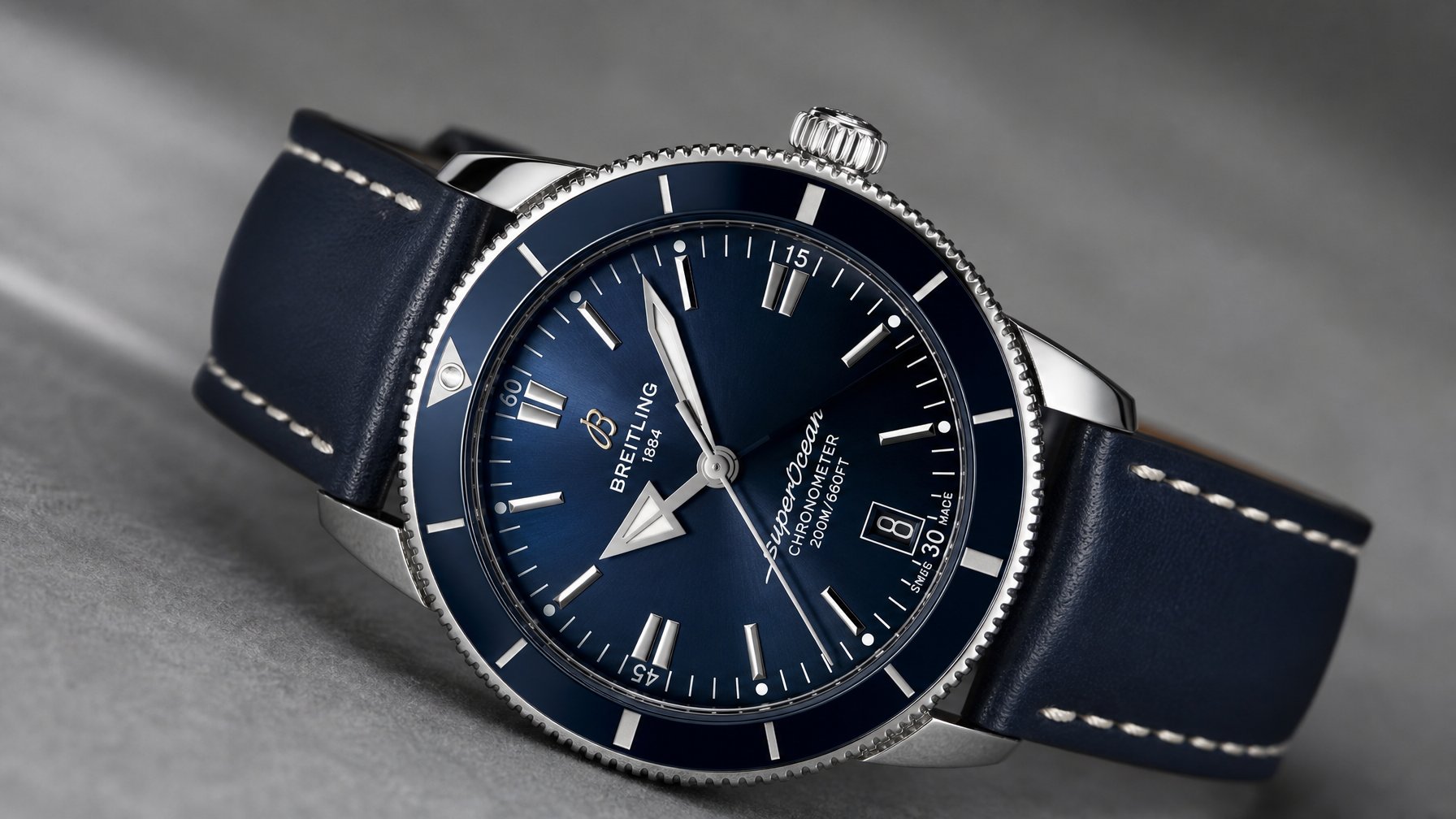 Foto close-up jam tangan diver premium dengan bezel bulat dan tali kulit biru.