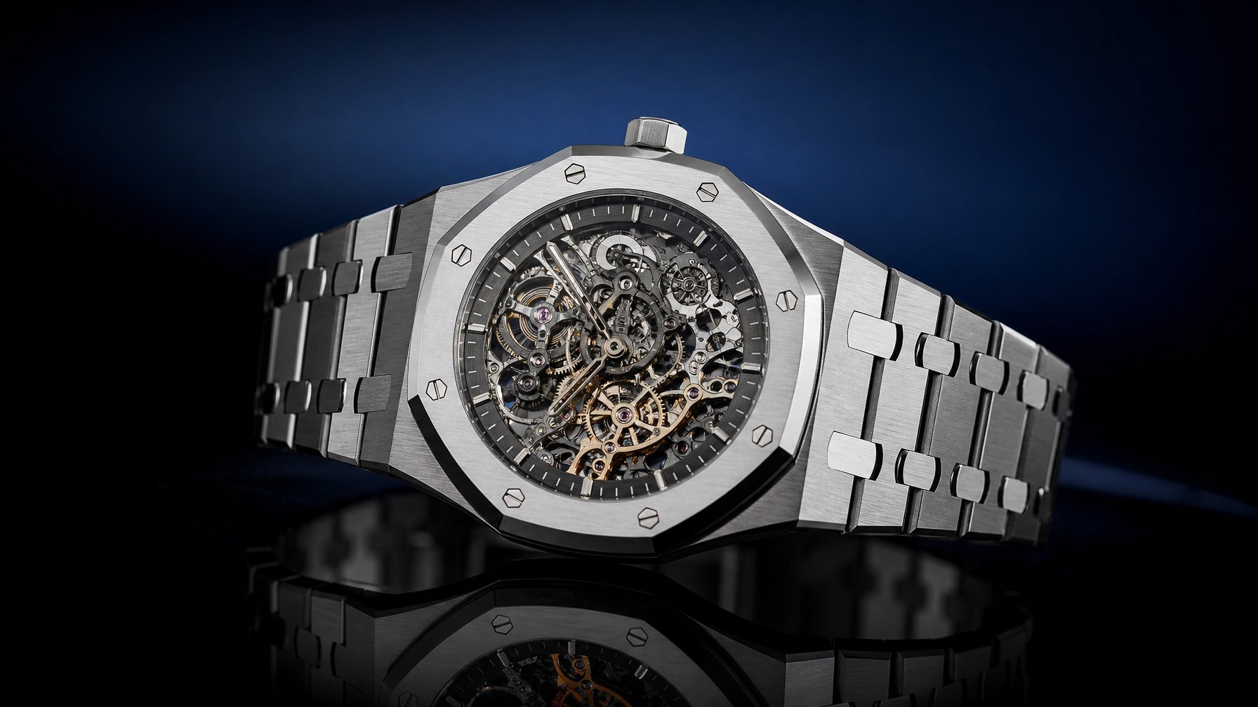 Jam tangan Audemars Piguet Royal Oak Jumbo Extra-Thin Openworked dengan dial terbuka yang menampilkan mekanisme rumit, diletakkan di atas permukaan gelap yang reflektif.