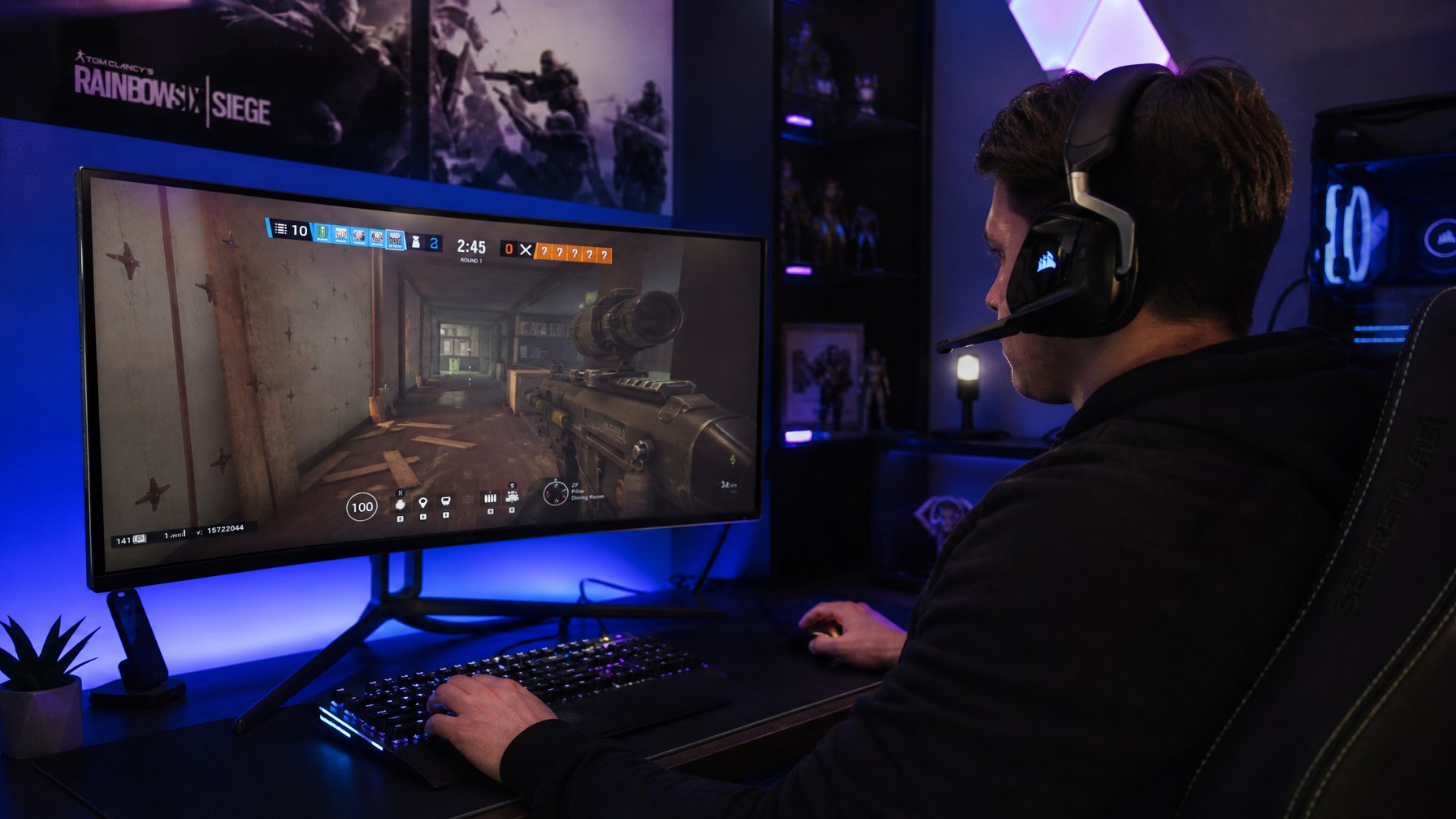 Seorang gamer muda duduk sendirian di ruang permainan dengan headset, fokus bermain game di depan monitor besar.
