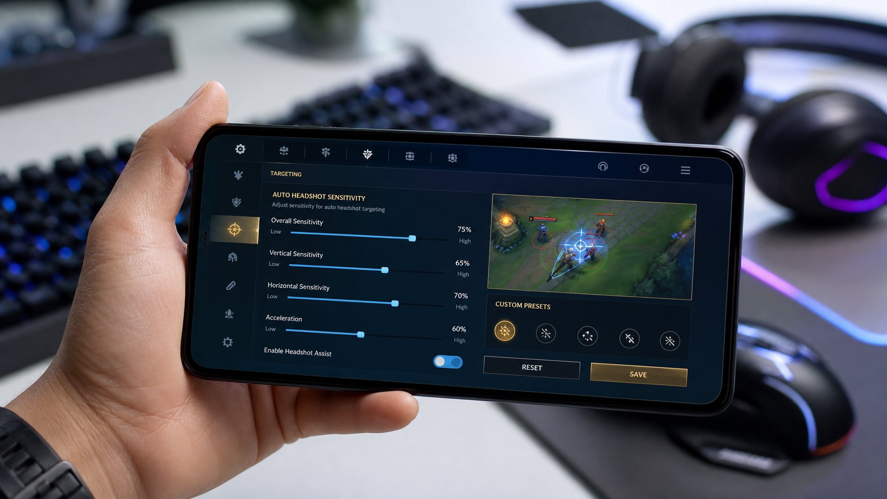 Seseorang memegang ponsel Android dengan layar pengaturan sensitivitas auto headshot untuk game mobile, di latar belakang terdapat perlengkapan gaming.
