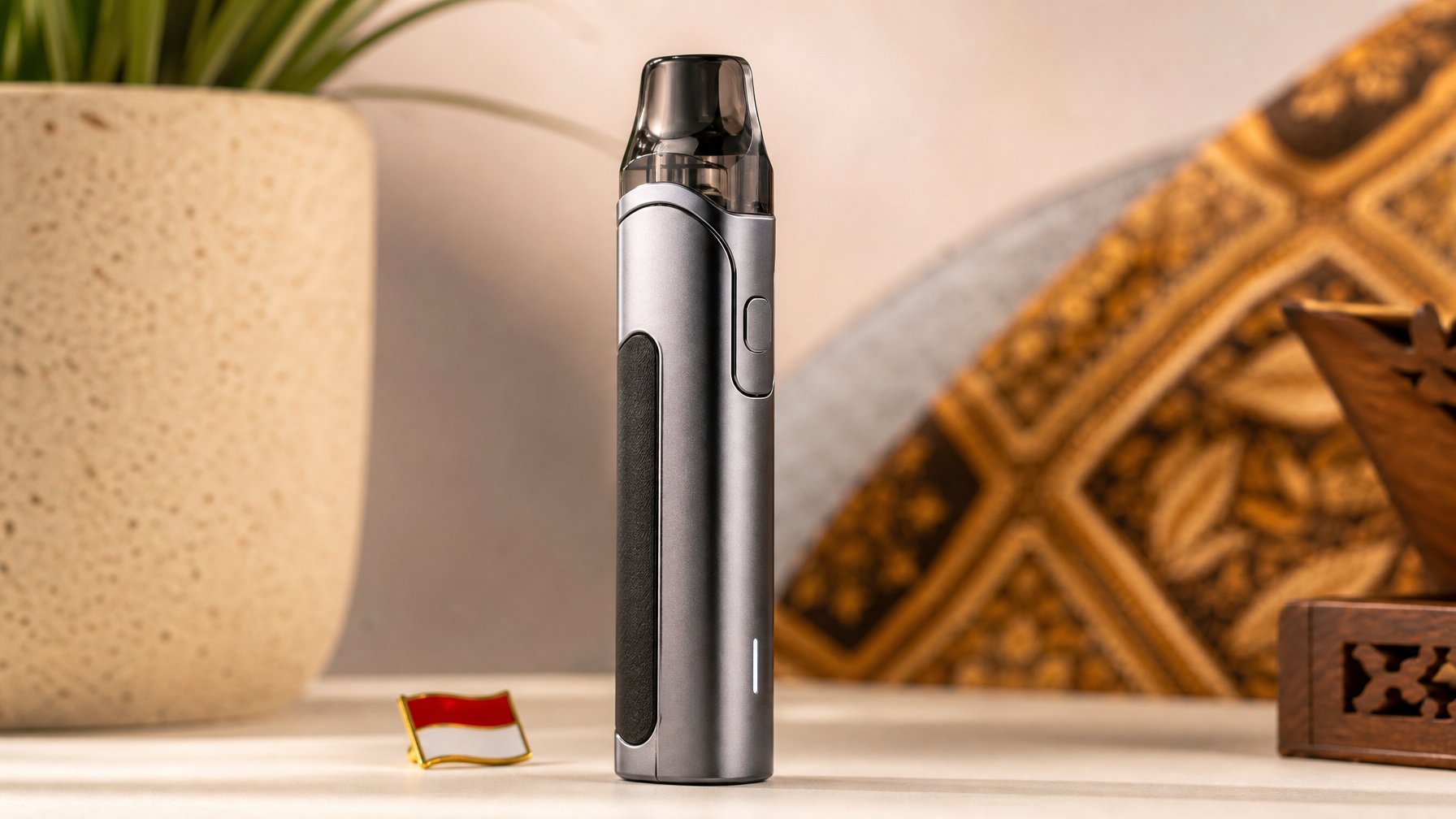 Sebuah perangkat vape modern dengan desain futuristik diletakkan di atas permukaan bersih dengan latar belakang yang menampilkan elemen budaya Indonesia secara samar.