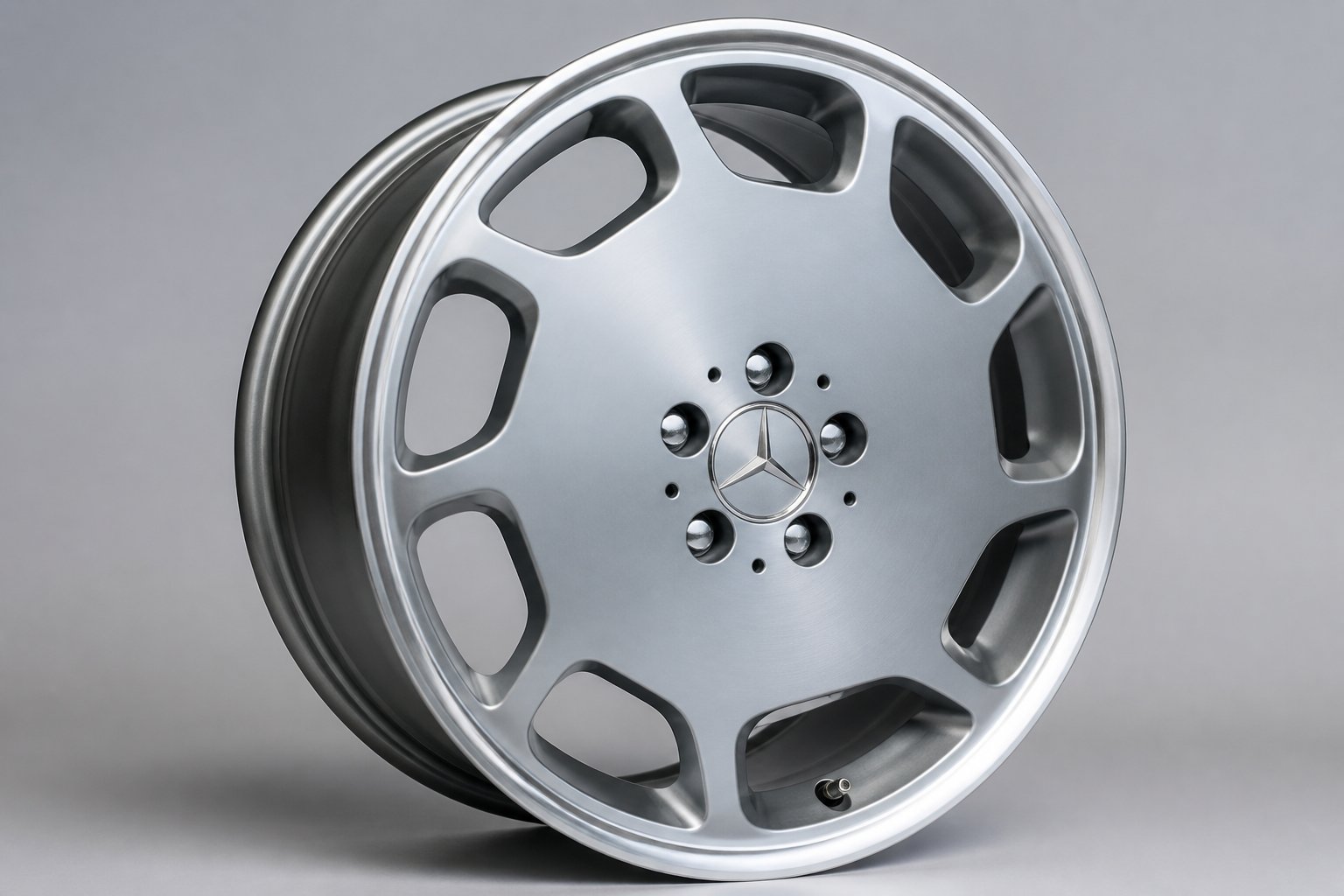 Close-up of a single 18-inch car wheel with a metallic finish on a plain background.