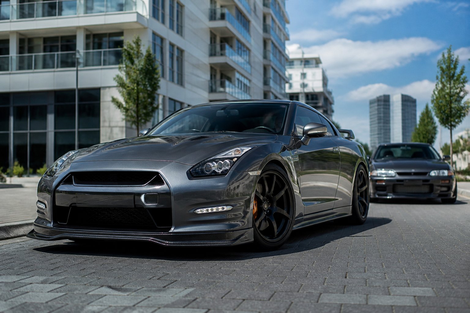 Een Nissan GTR R35 geparkeerd op een straat in een Duitse stad, met een Nissan Skyline R32 GTR op de achtergrond.