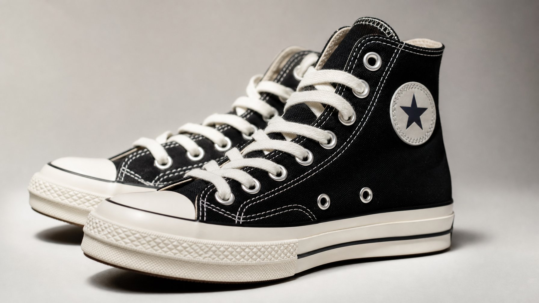 Sepasang sepatu Converse yang menampilkan desain dan kualitas material dengan latar belakang netral.