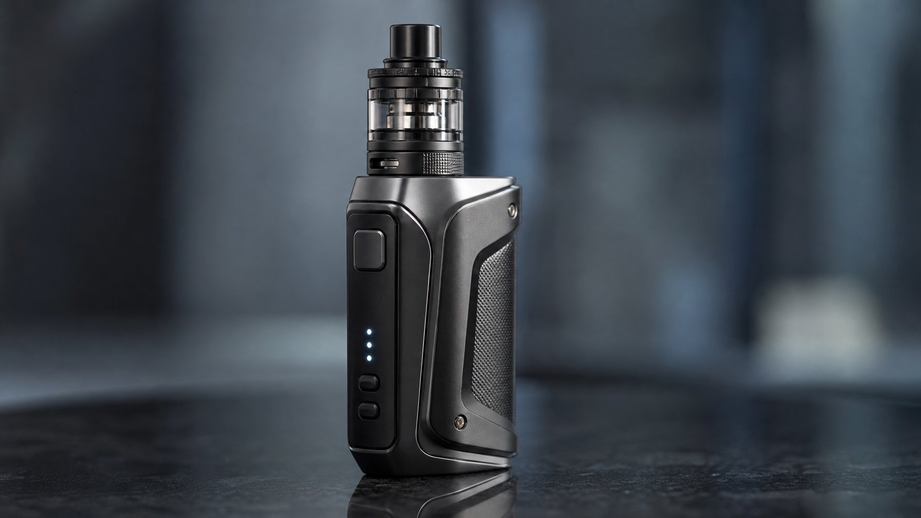 Sebuah perangkat vape mod modern dengan dua baterai 18650 diletakkan di atas permukaan reflektif dengan latar belakang minimalis.