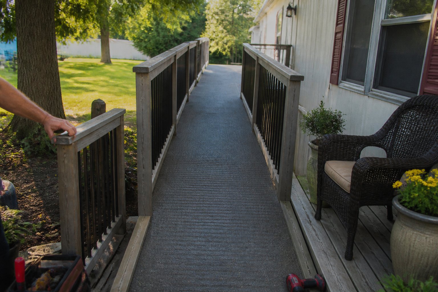 A ramp-friendly entry deck with non-slip treads leading to a mobile home, with hands and tools resting nearby.
