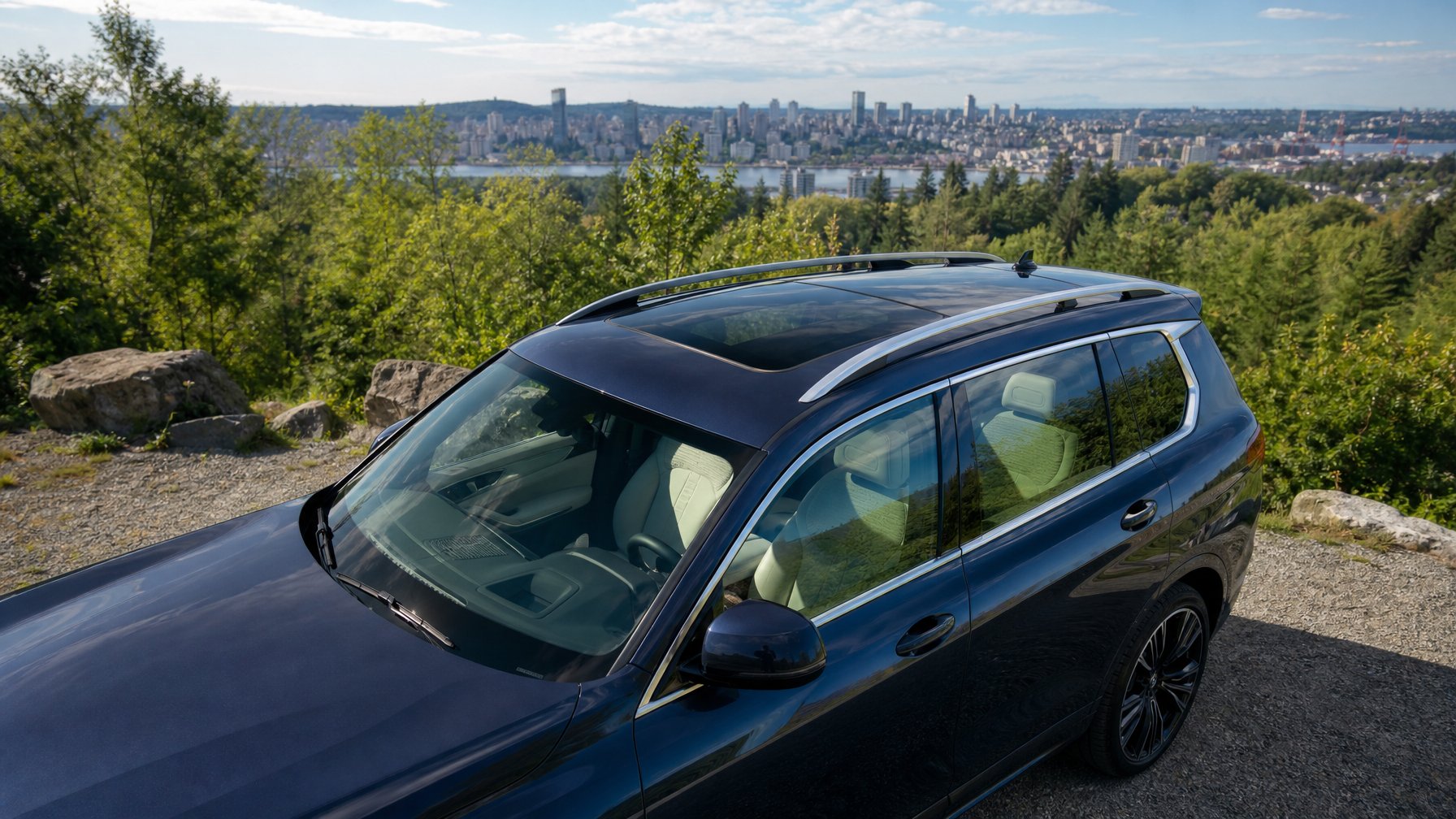 Sebuah mobil SUV modern dengan sunroof panoramik besar, diparkir di luar ruangan dengan latar langit biru dan pepohonan hijau.