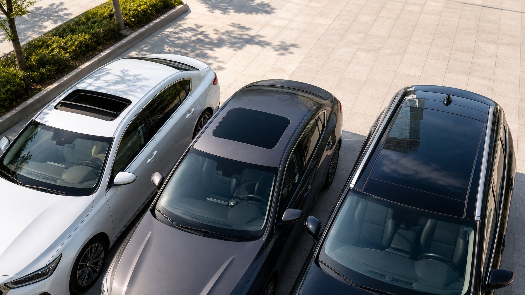 Tiga mobil modern berdampingan dengan atap sunroof, moonroof, dan panoramic roof yang berbeda terlihat jelas dari atas.