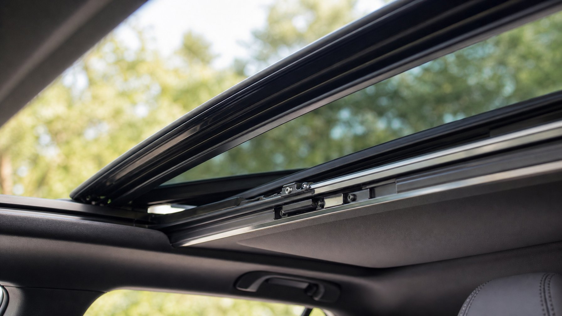 Tampilan dekat rel sunroof mobil yang sedang dibuka atau ditutup di dalam kabin mobil.