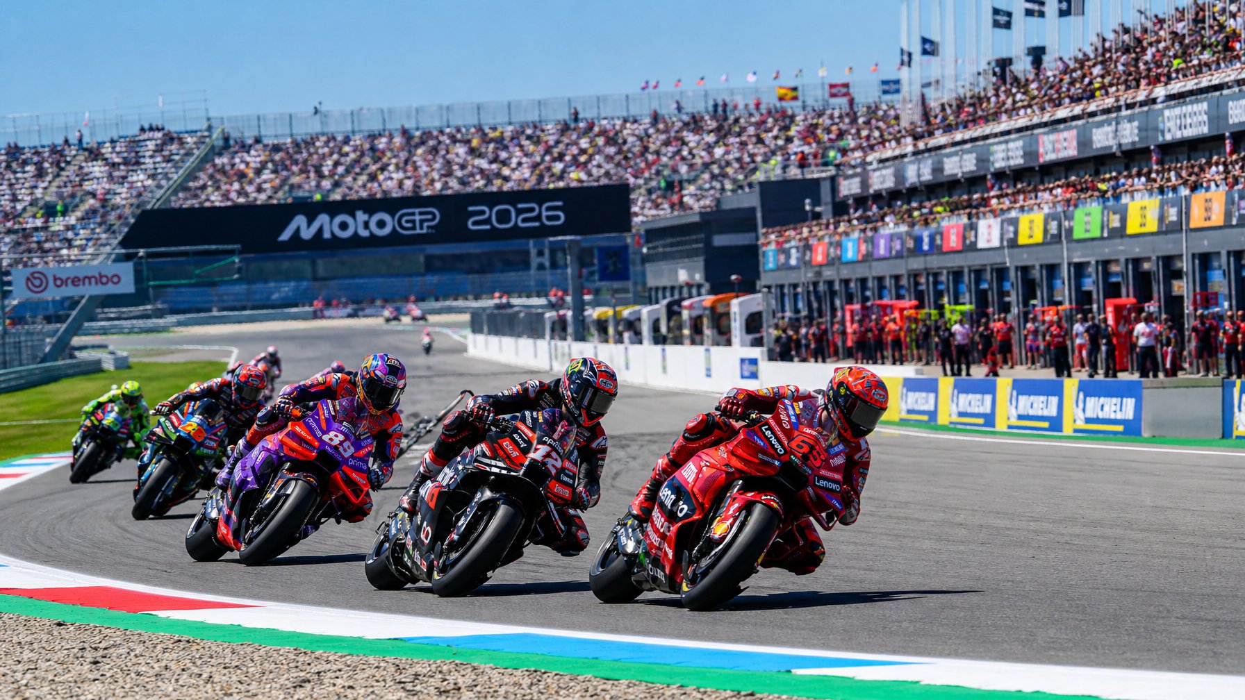 Beberapa pembalap MotoGP sedang balapan cepat di lintasan dengan penonton di tribun dan suasana kompetisi yang intens.