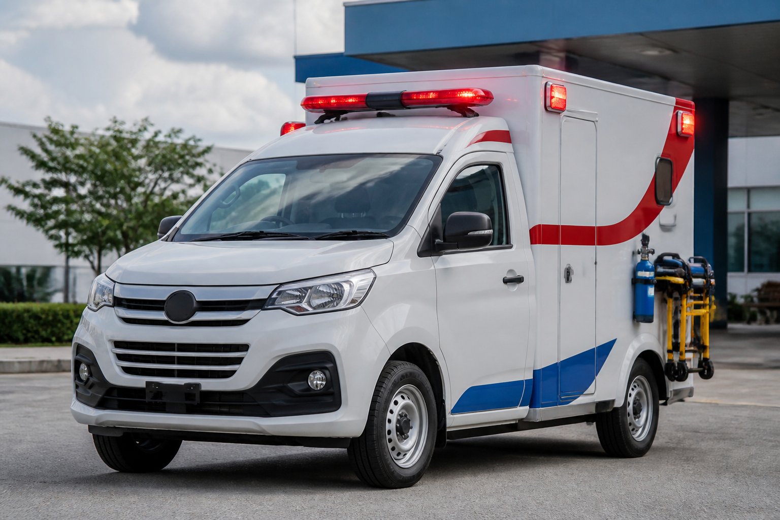 Carro ambulância branco com detalhes vermelhos e azuis estacionado em uma área urbana durante o dia.