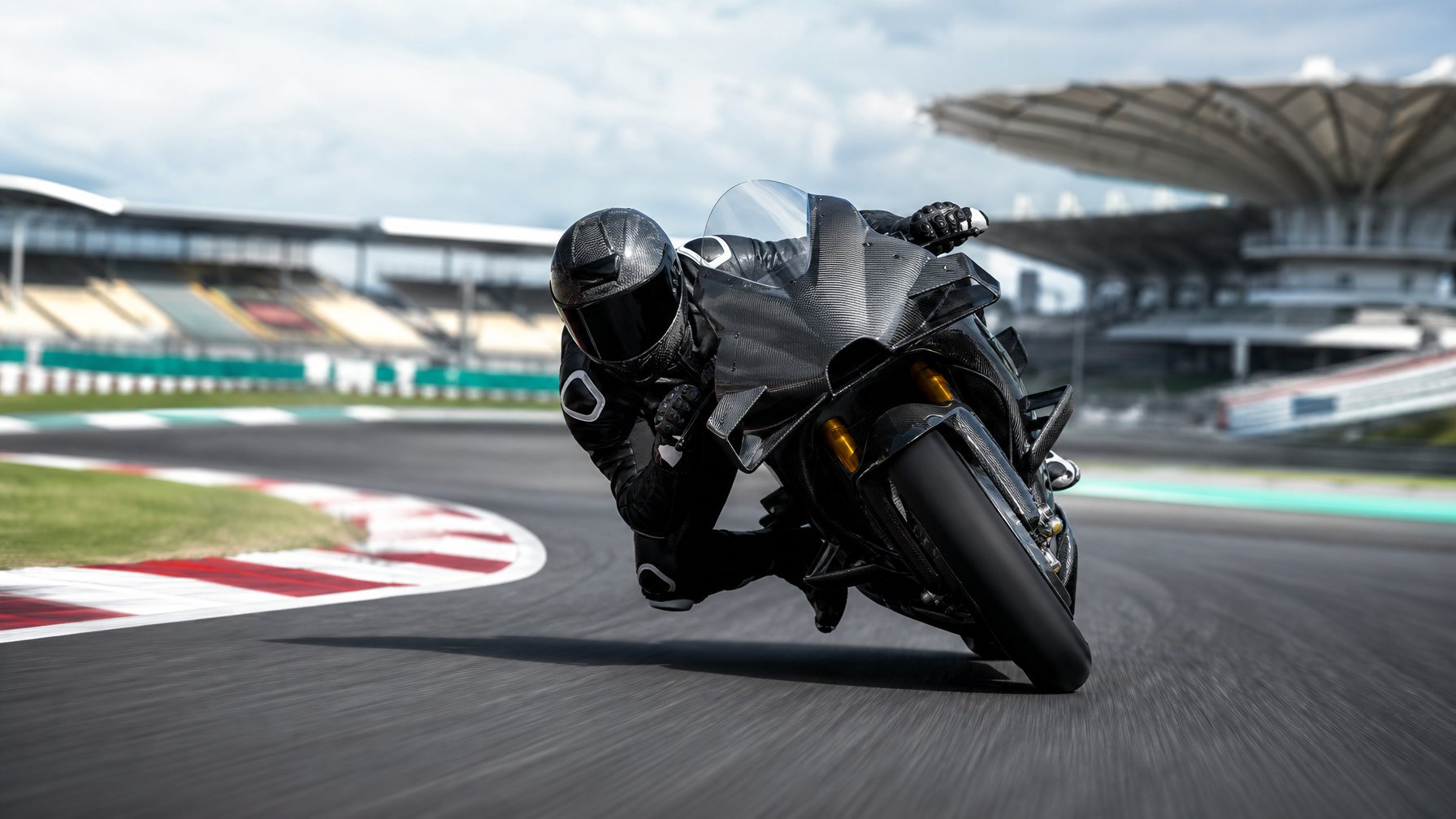 Sepeda motor balap MotoGP melaju di tikungan sirkuit dengan tribun dan fasilitas balap di latar belakang.