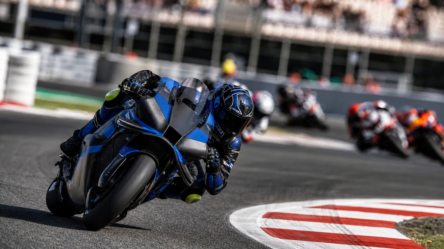 Raúl Fernández melaju cepat dengan sepeda motor balap di tikungan sirkuit MotoGP, diikuti beberapa pembalap lain.