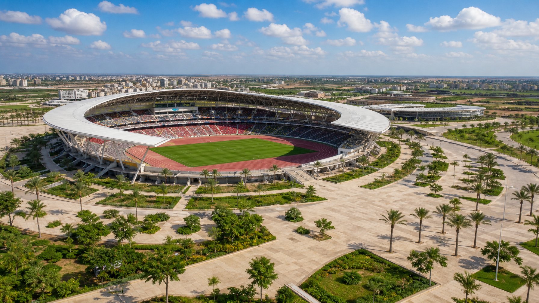 Stadion modern utama di kawasan Diamniadio, Senegal, dikelilingi jalur pejalan kaki, pepohonan palem, dan lanskap perkotaan.