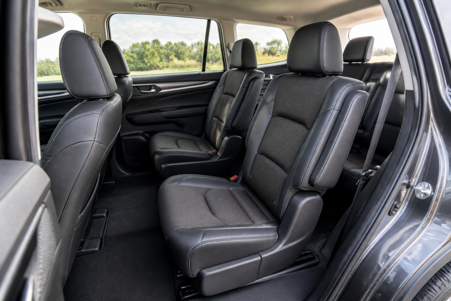 Interior mobil SUV tiga baris dengan sarung jok premium berwarna gelap yang terpasang rapi.