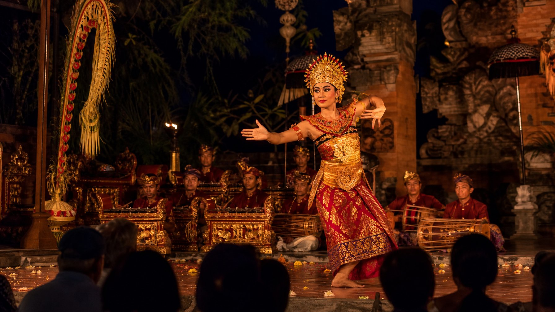 Penari Bali tampil di panggung terbuka pada malam hari dengan iringan gamelan di Ubud.