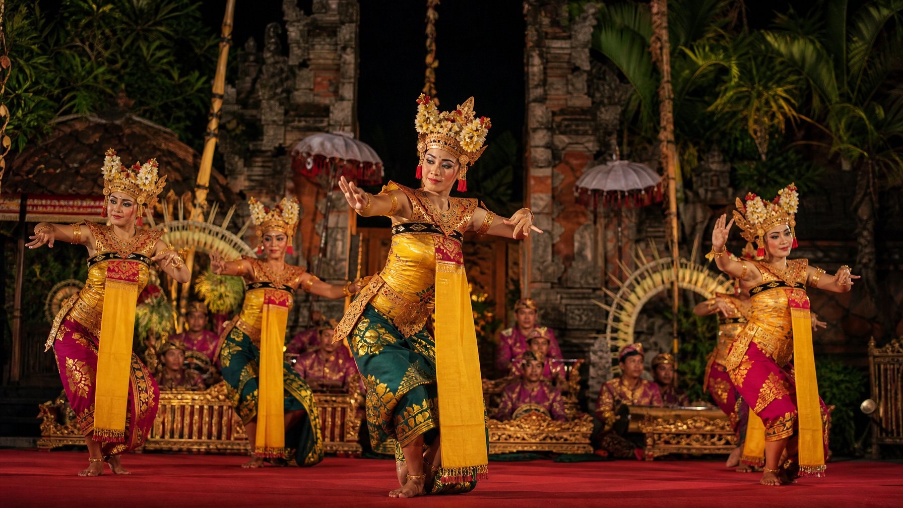 Penari tradisional Bali tampil di panggung terbuka pada malam hari dengan iringan gamelan di halaman pura.