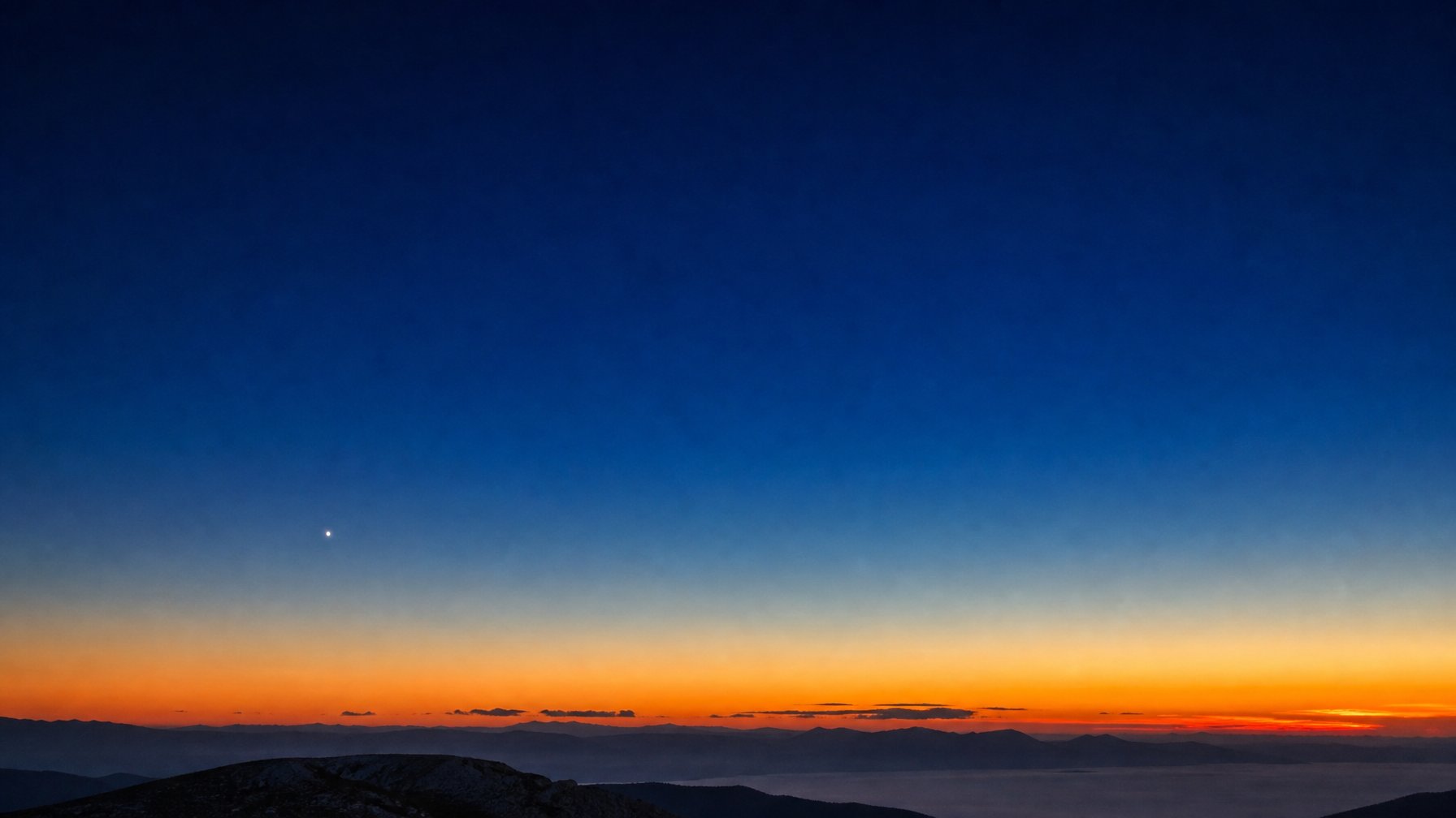 Merkurius tampak sebagai titik terang di atas cakrawala saat langit senja berubah dari jingga menjadi biru.