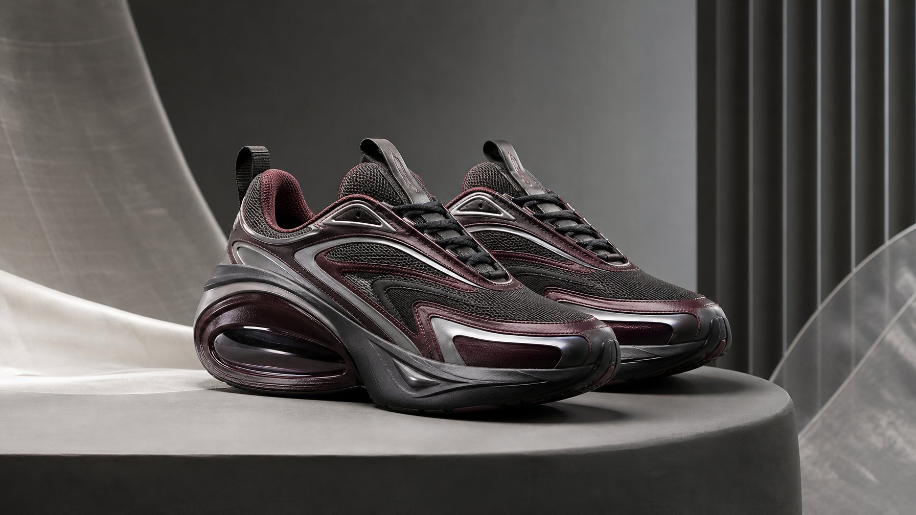 Sepasang sepatu sneaker futuristis ditampilkan di atas pedestal dalam ruang studio modern.