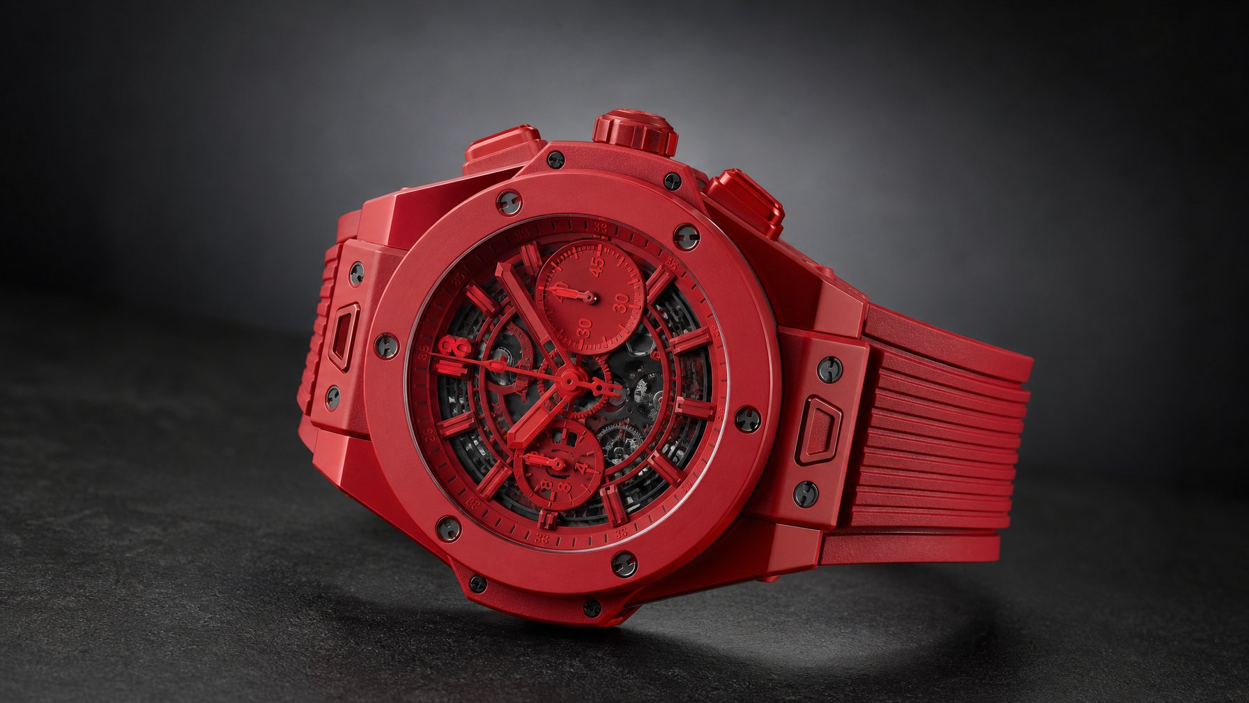 Jam tangan kronograf merah diletakkan di atas permukaan gelap dalam pencahayaan studio.