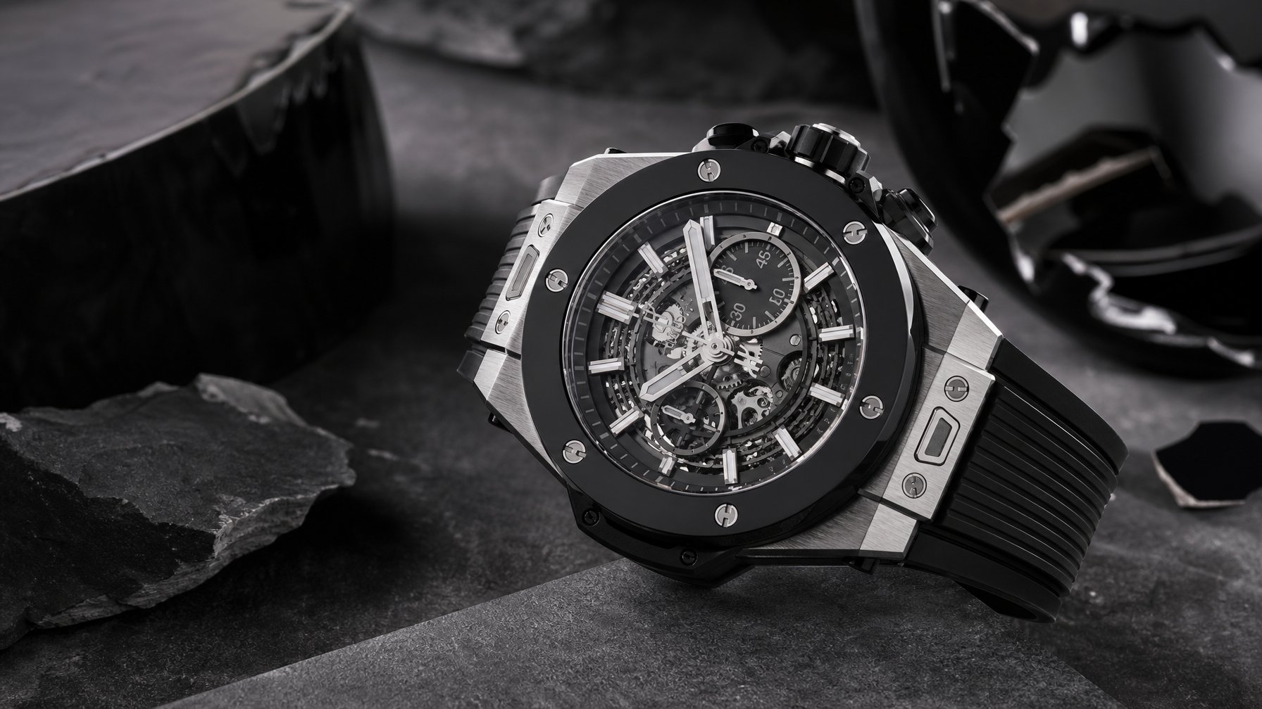 Jam tangan kronograf mewah berbahan titanium dengan bezel keramik hitam ditampilkan di atas permukaan gelap.