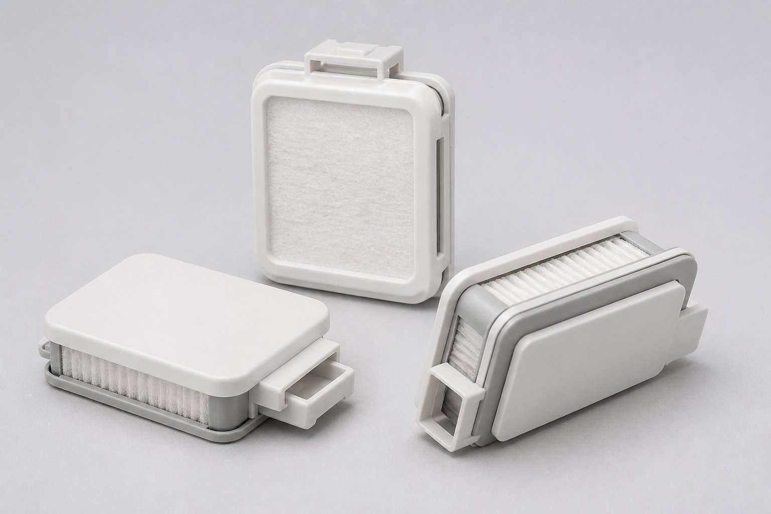 Several small white and gray replacement air filters for a compact breathing device arranged on a clean studio surface.