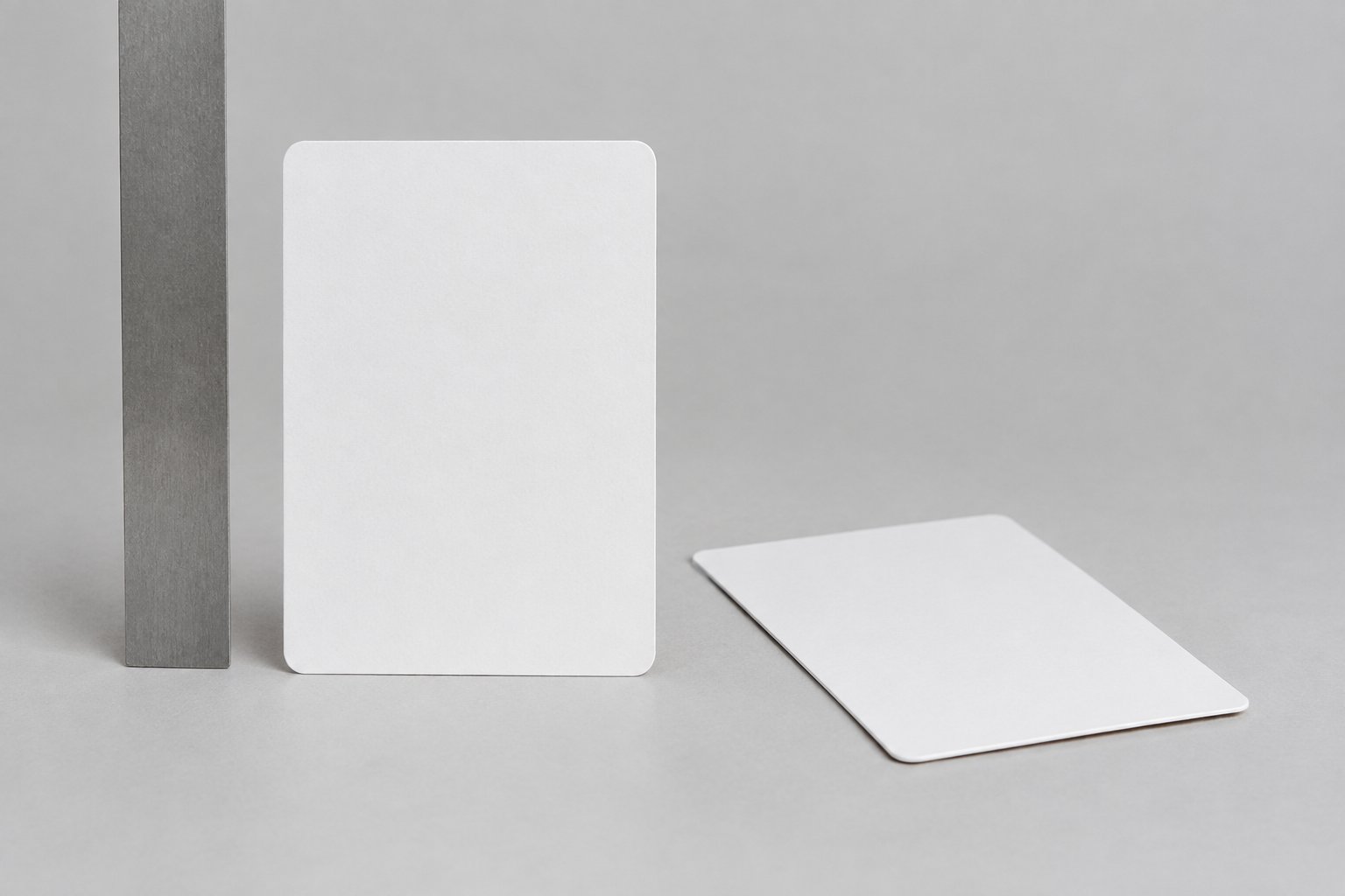 Two blank collectible cards beside a ruler on a tabletop.