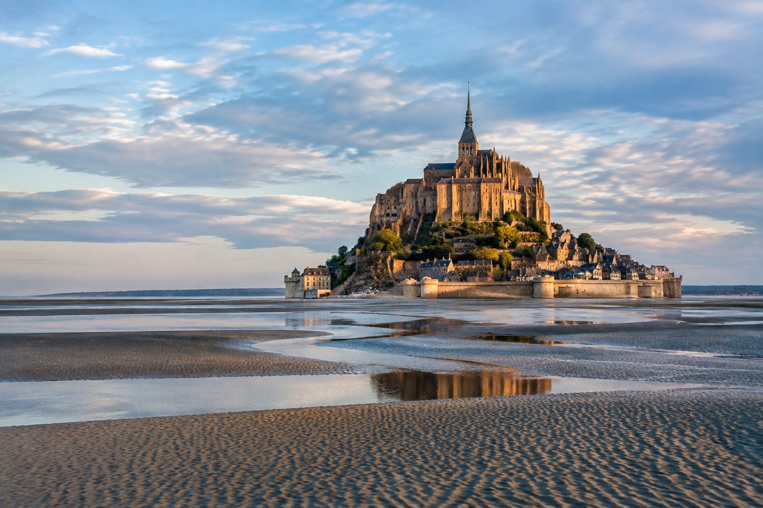 Mont-Saint-Michel rises above tidal flats and shallow channels.