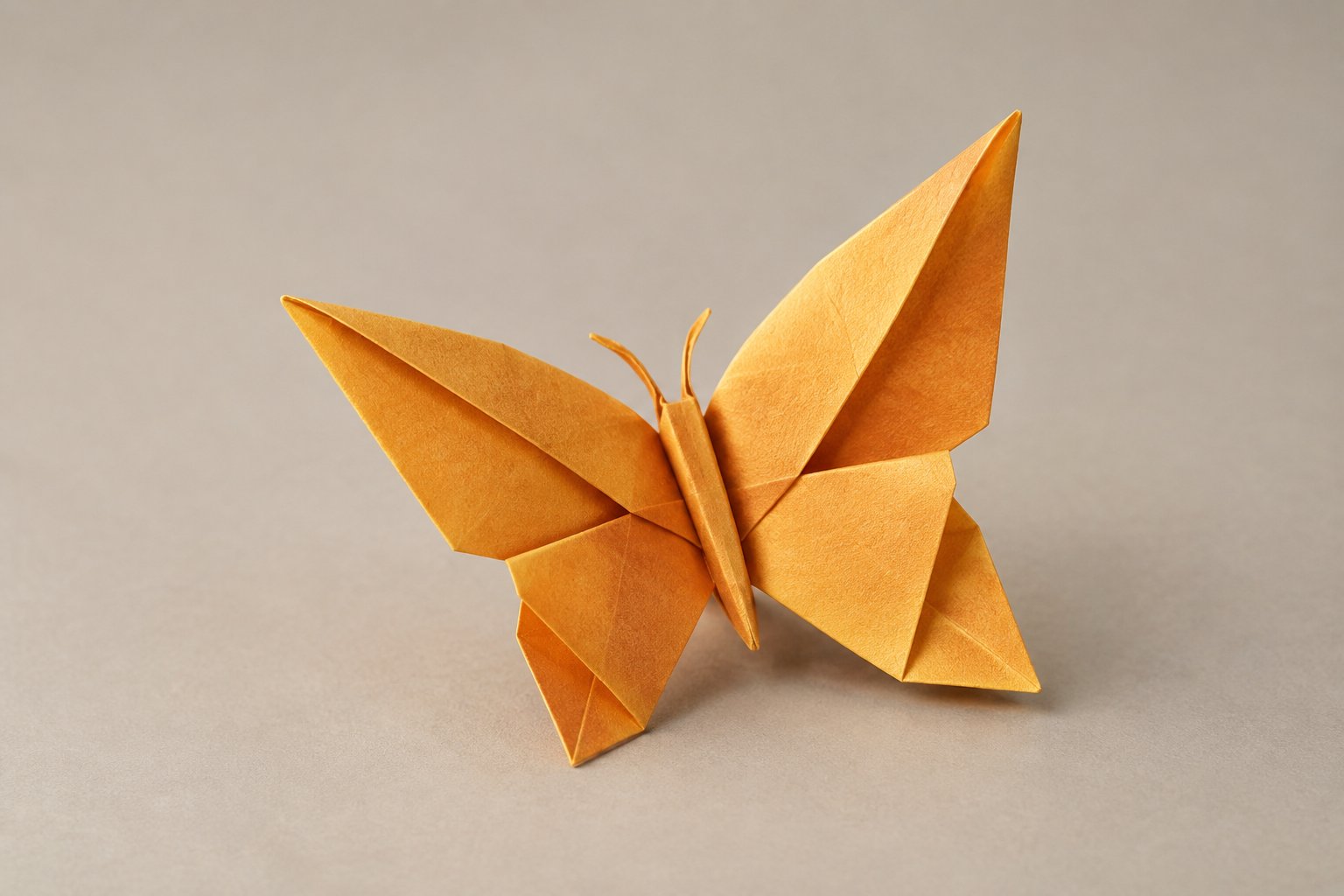 A folded paper butterfly rests on a flat surface.