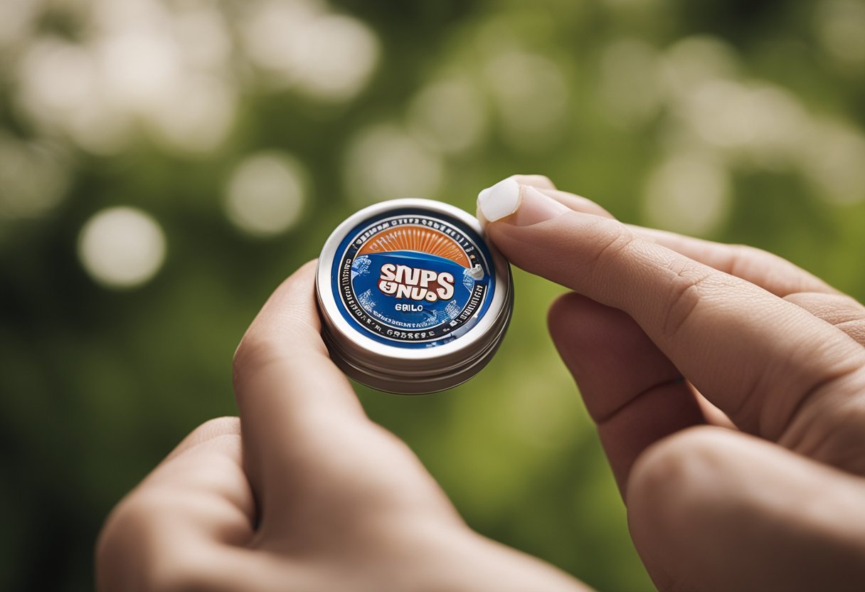 A hand reaches for a small, round container of snus. The lid is twisted off, and the user places a portion of the tobacco product under their upper lip
