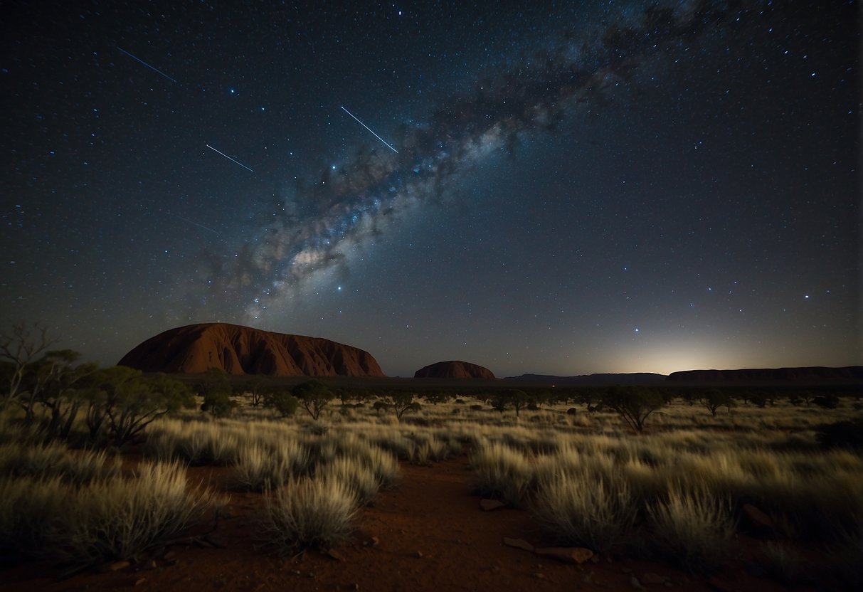 The vast outback stretches under a clear night sky. The Milky Way shines brightly above Uluru, while the Southern Cross stands out over the dark expanse of the Outback