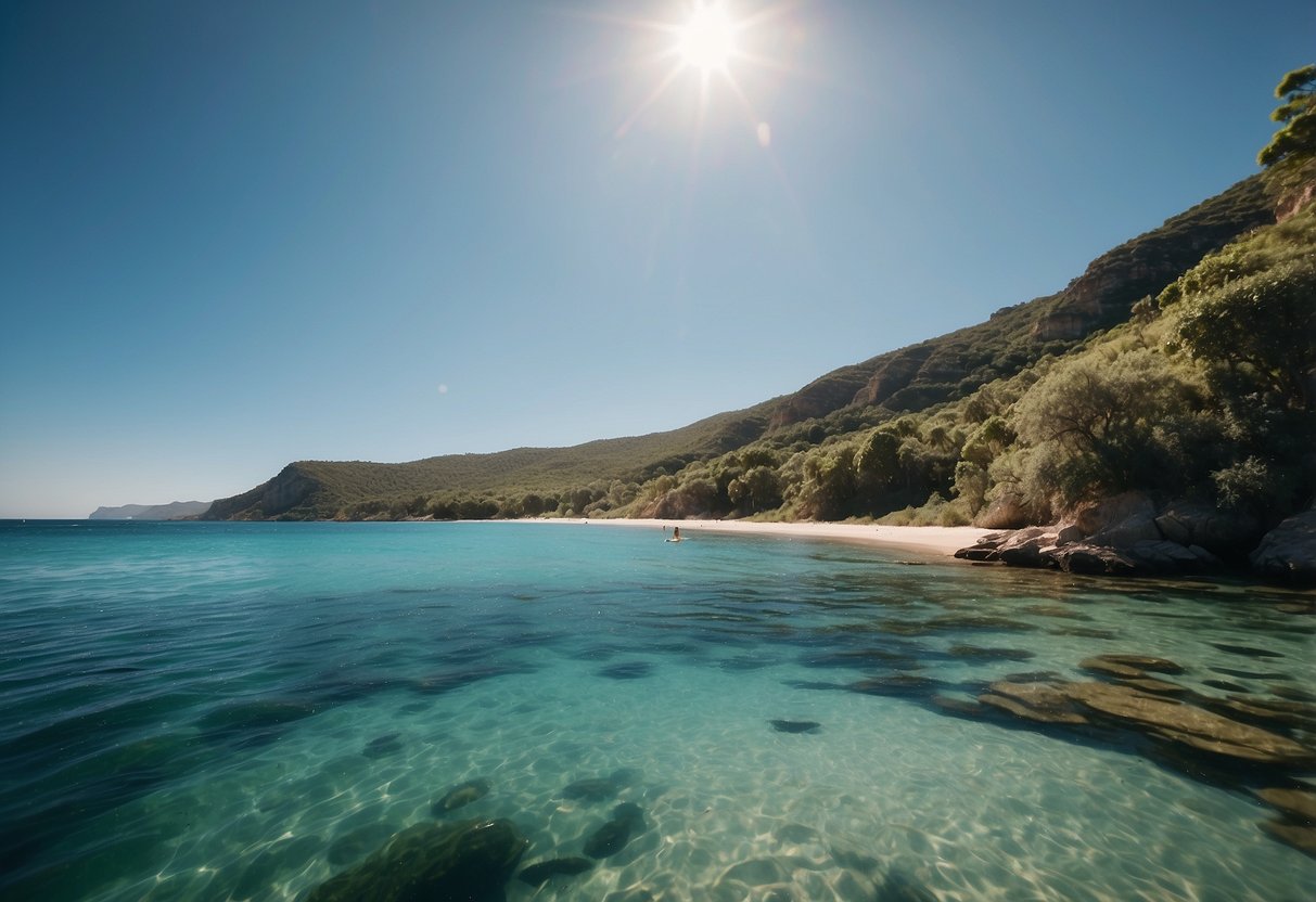 Crystal clear waters lap against the sandy shore as paddleboards glide along the coastline. Lush greenery and rugged cliffs frame the tranquil scene