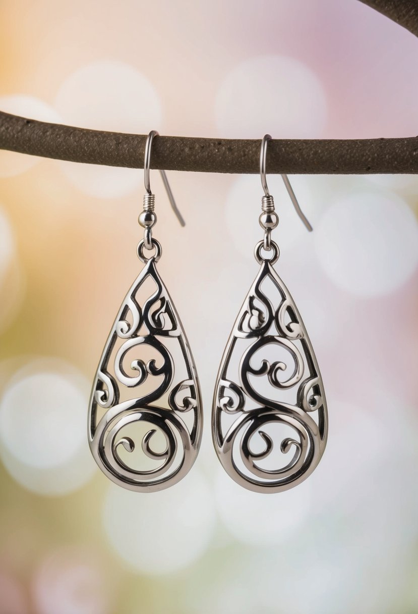 A pair of elegant teardrop earrings with intricate swirl designs, set against a soft, romantic background