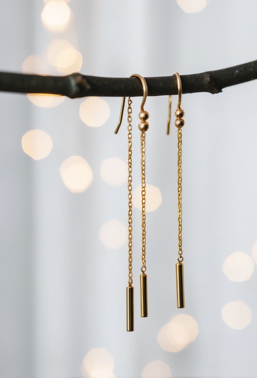 Two delicate gold threader earrings hang against a white backdrop, casting a subtle shimmer in the soft light