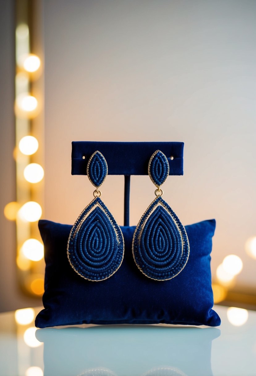 A pair of elegant navy statement drop earrings displayed on a velvet cushion with soft lighting highlighting their intricate design